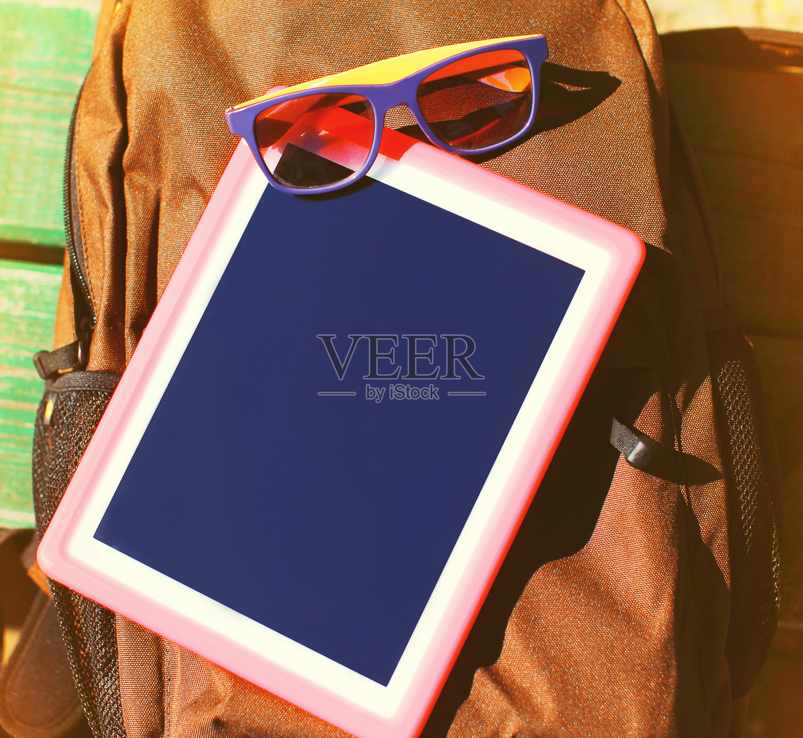 近黑屏数字平板电脑和太阳镜背包照片摄影图片