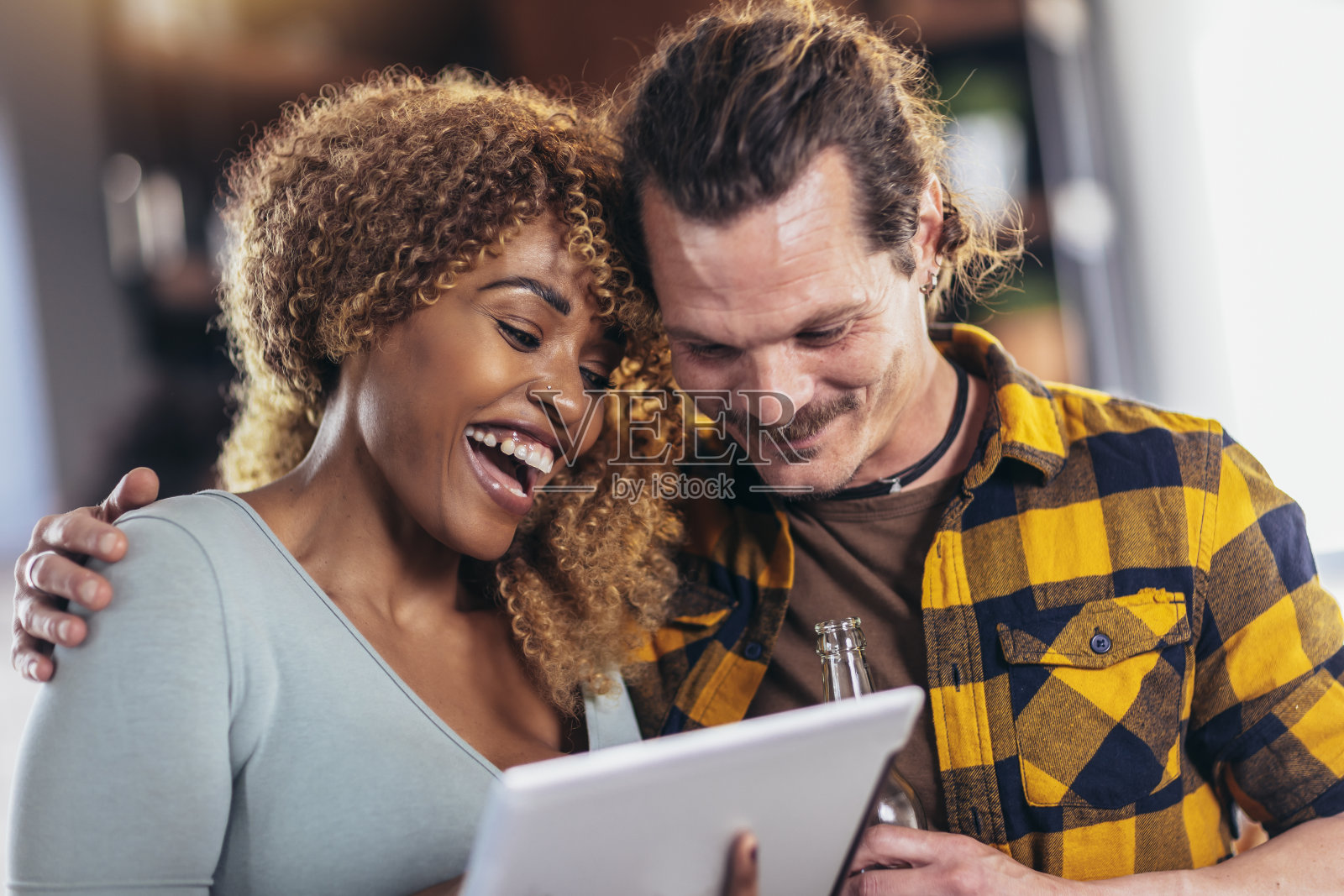 情侣们一边看平板电脑一边娱乐。照片摄影图片