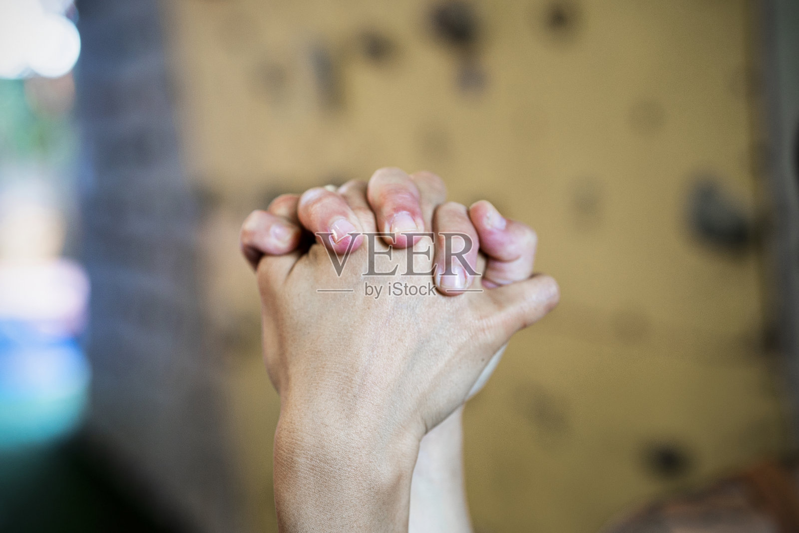 年轻女子站在抱石墙旁击掌后手拉着手照片摄影图片