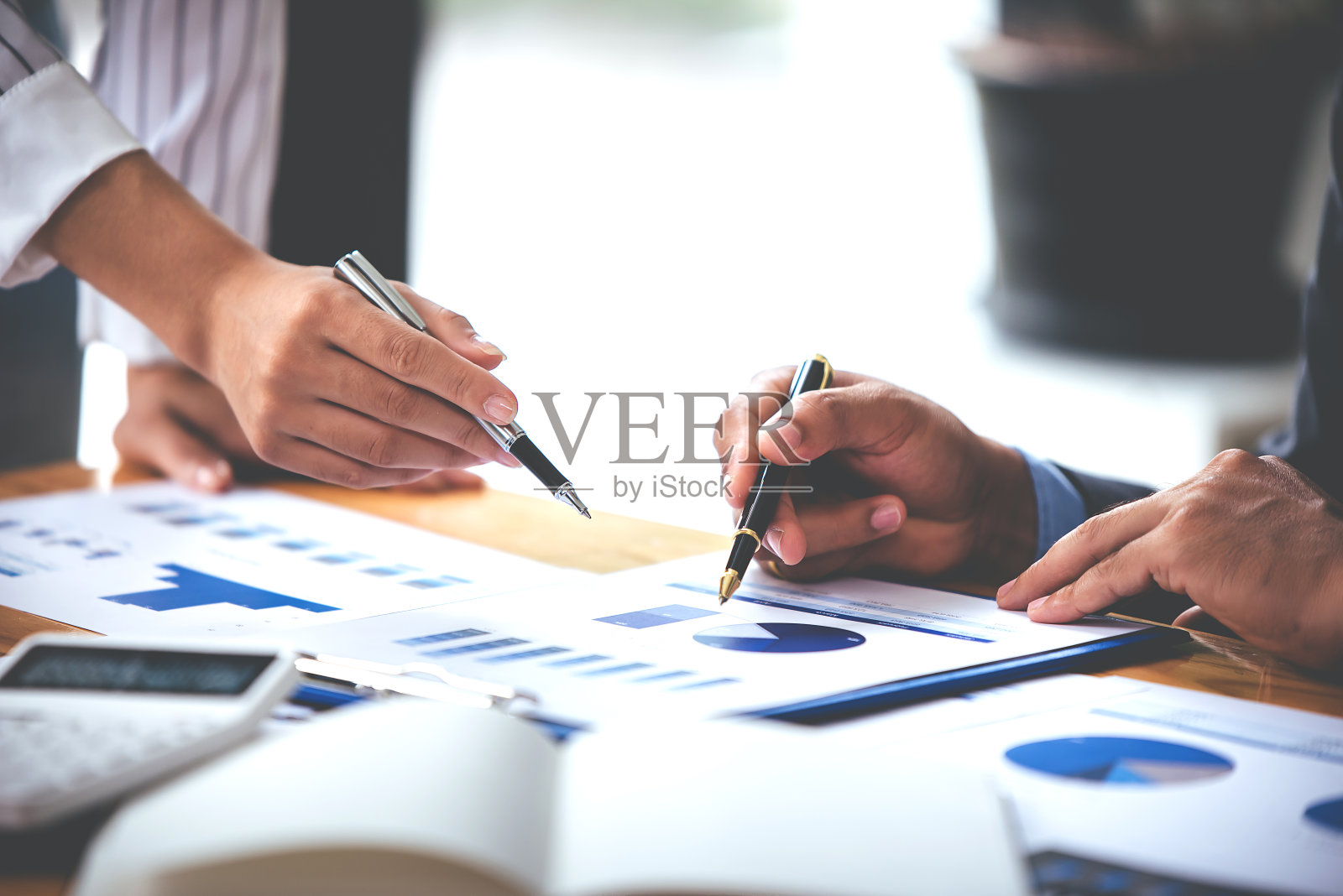 团队合作，将商业分析价格图表放在会议室的桌子上。照片摄影图片