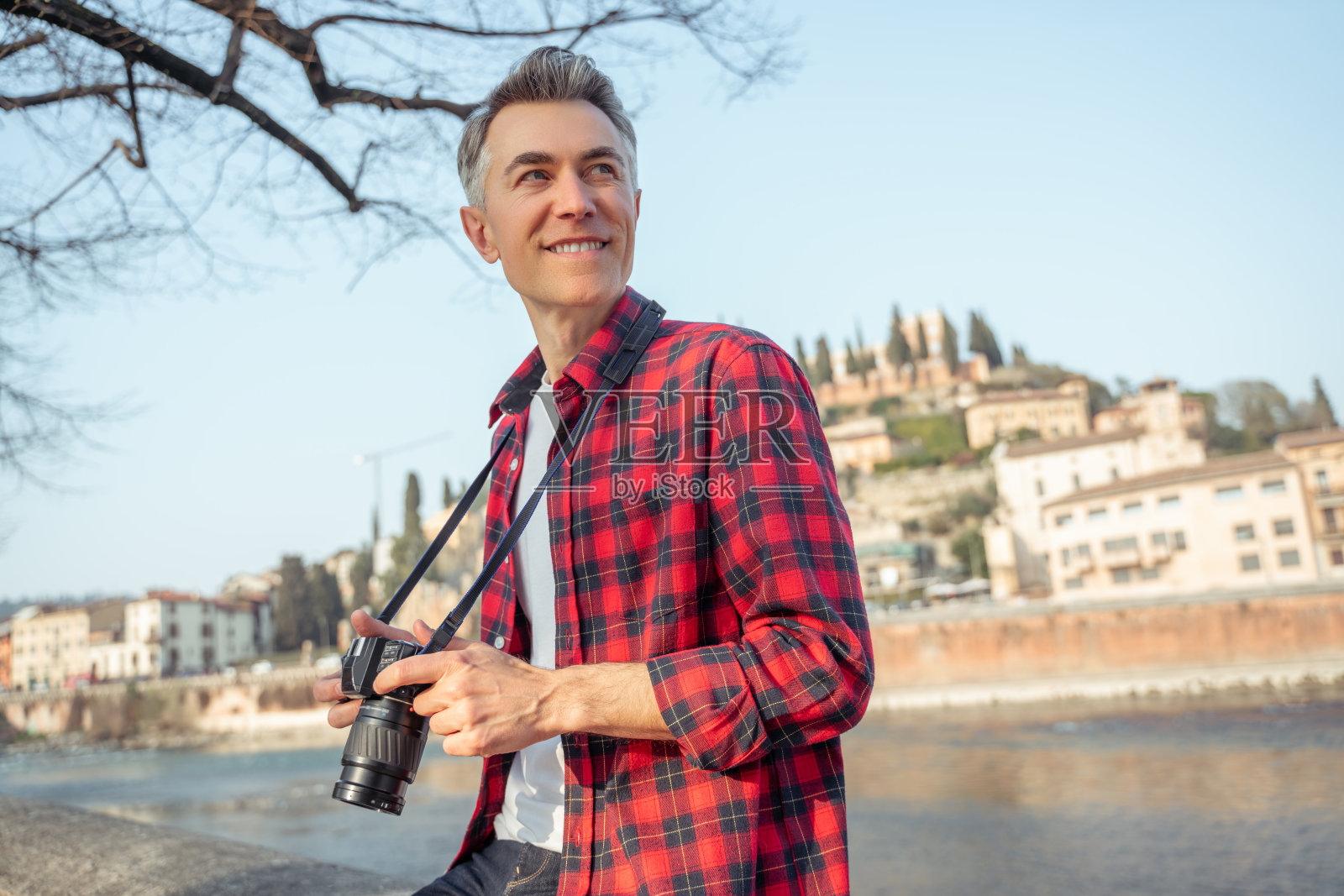 手里拿着相机的男人看向别处的灵感照片摄影图片