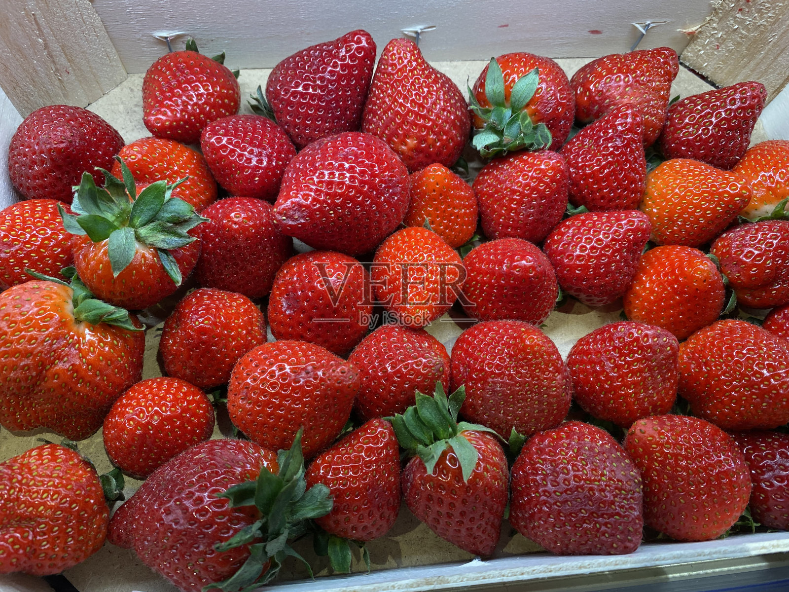 小篮子里放着一排鲜红多汁的草莓照片摄影图片