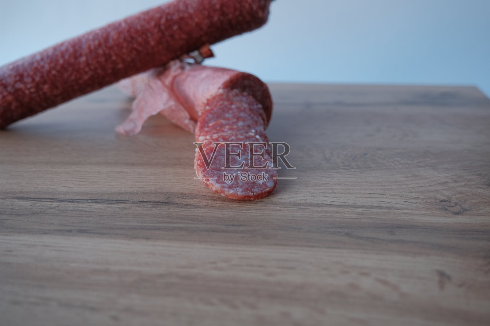 意大利香肠片。意大利腊肠切片放在意大利腊肠背景上照片摄影图片