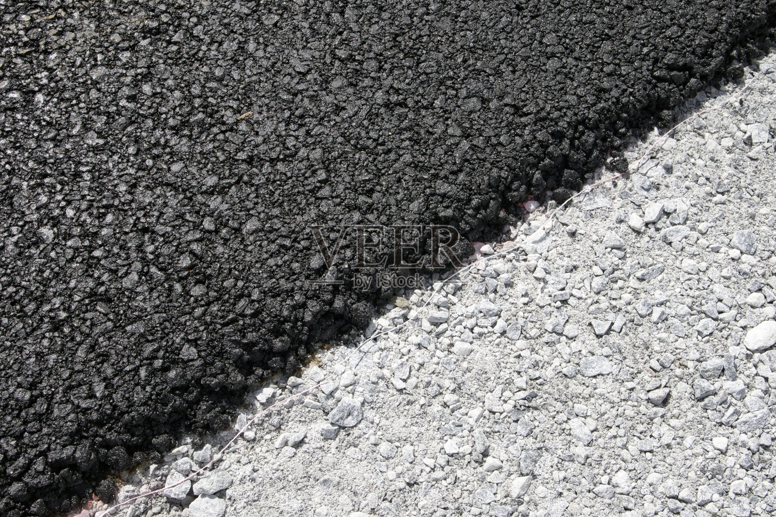 一层新鲜的黑色沥青在灰色的砾石上照片摄影图片