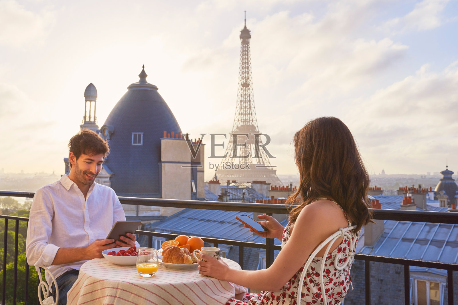 年轻情侣在阳台上用早餐，俯瞰法国巴黎埃菲尔铁塔照片摄影图片