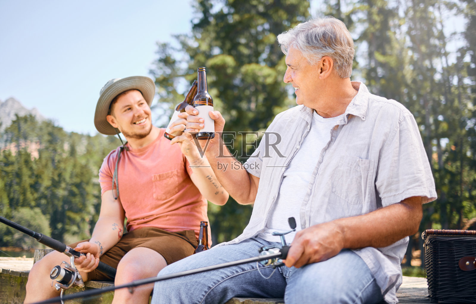 男人和父亲在森林湖边一起钓鱼喝啤酒照片摄影图片