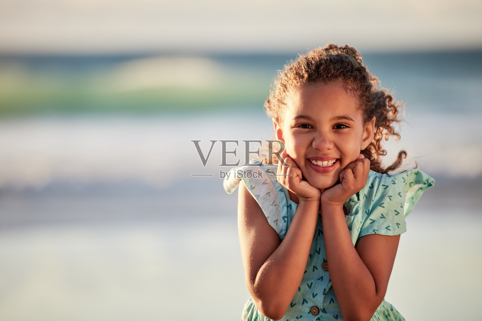 一个可爱的小女孩在海滩上玩得很开心照片摄影图片