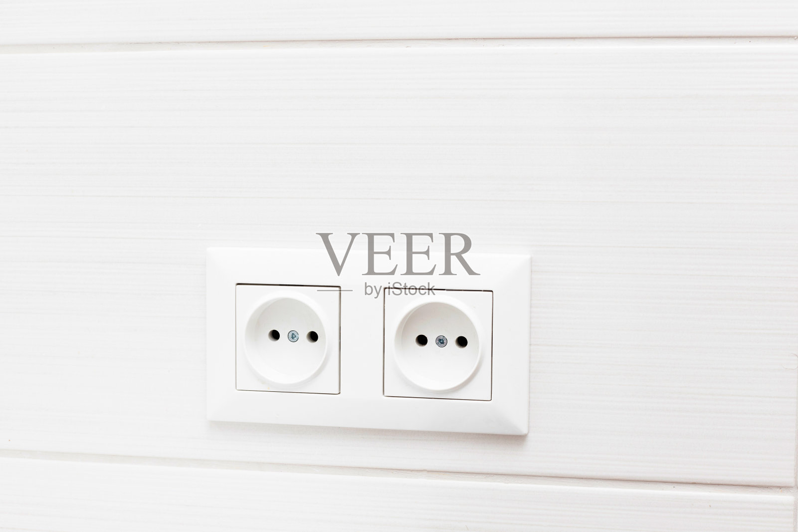 白色瓷砖墙上有两个插座。浴室内照片摄影图片