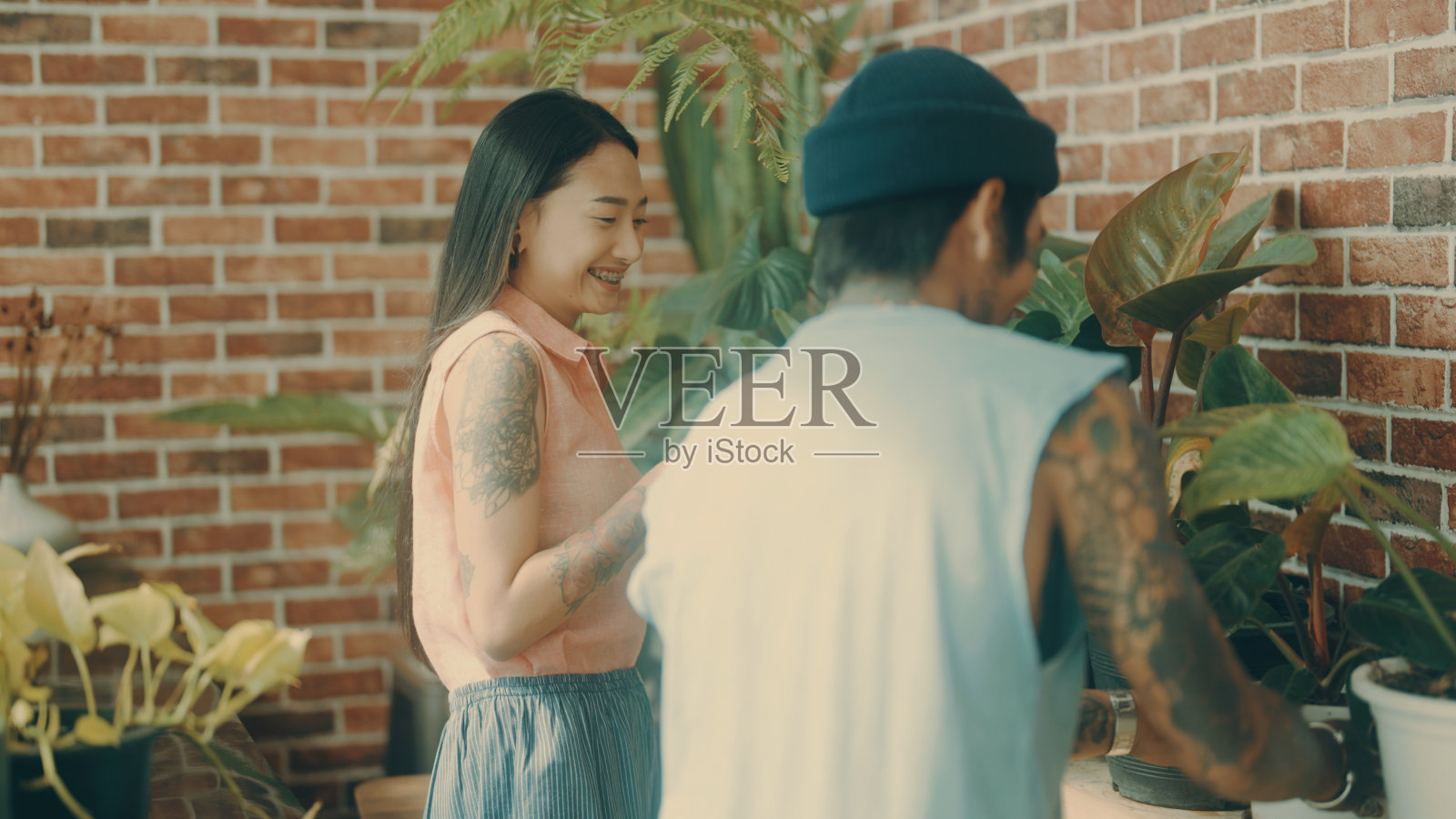 亚洲夫妇在家里照顾植物。照片摄影图片