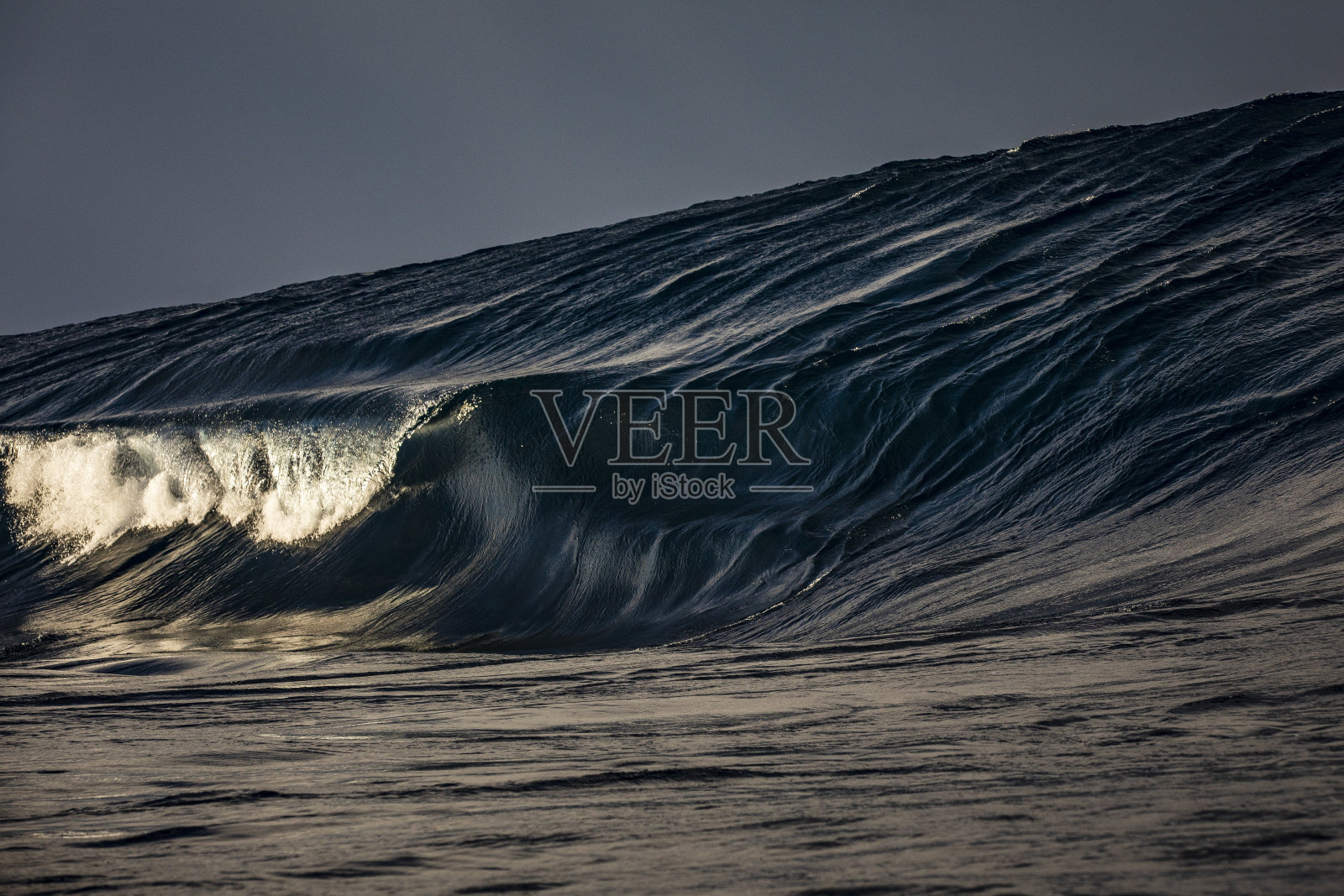 巨大的开放海洋膨胀线形成一个波浪在一个温暖的晨光浅礁岩照片摄影图片