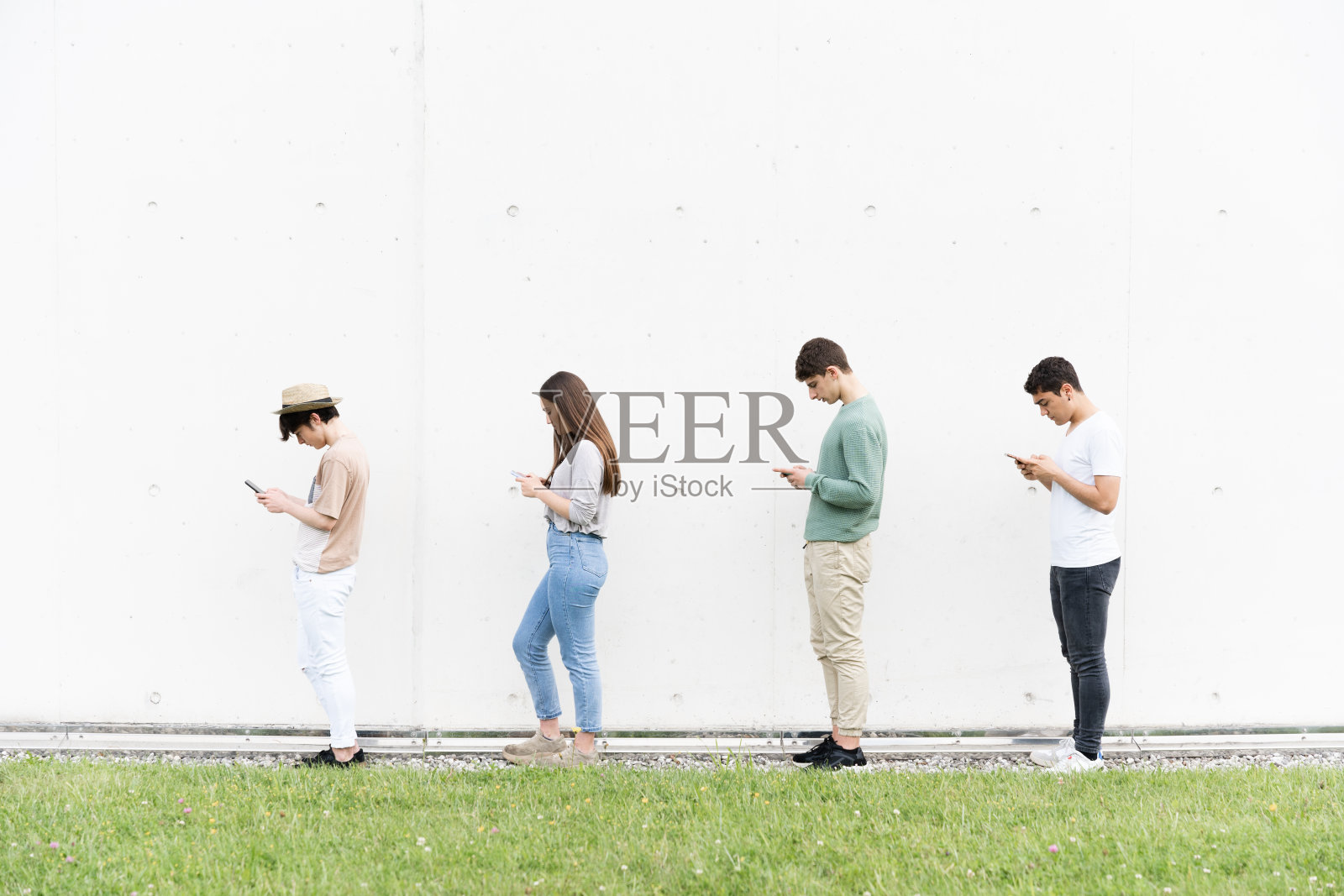 排队时使用手机的青少年照片摄影图片