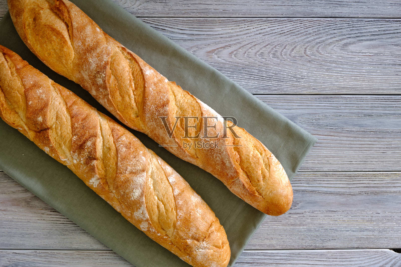 木板上的新鲜脆皮法棍照片摄影图片