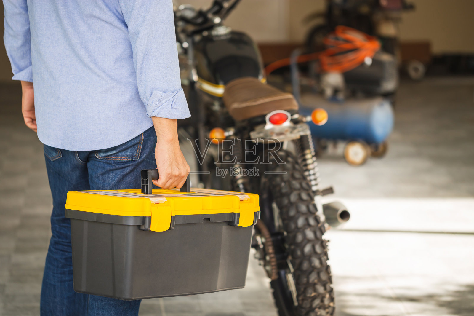 技术人员携带工具箱在修理店修理摩托车照片摄影图片