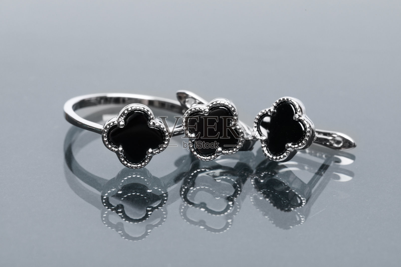 戒指和耳环与黑色珐琅组成照片摄影图片