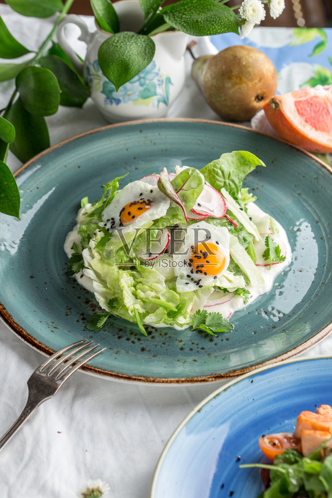 新鲜的鸡蛋、萝卜和芝麻混合沙拉放在绿色的盘子上照片摄影图片