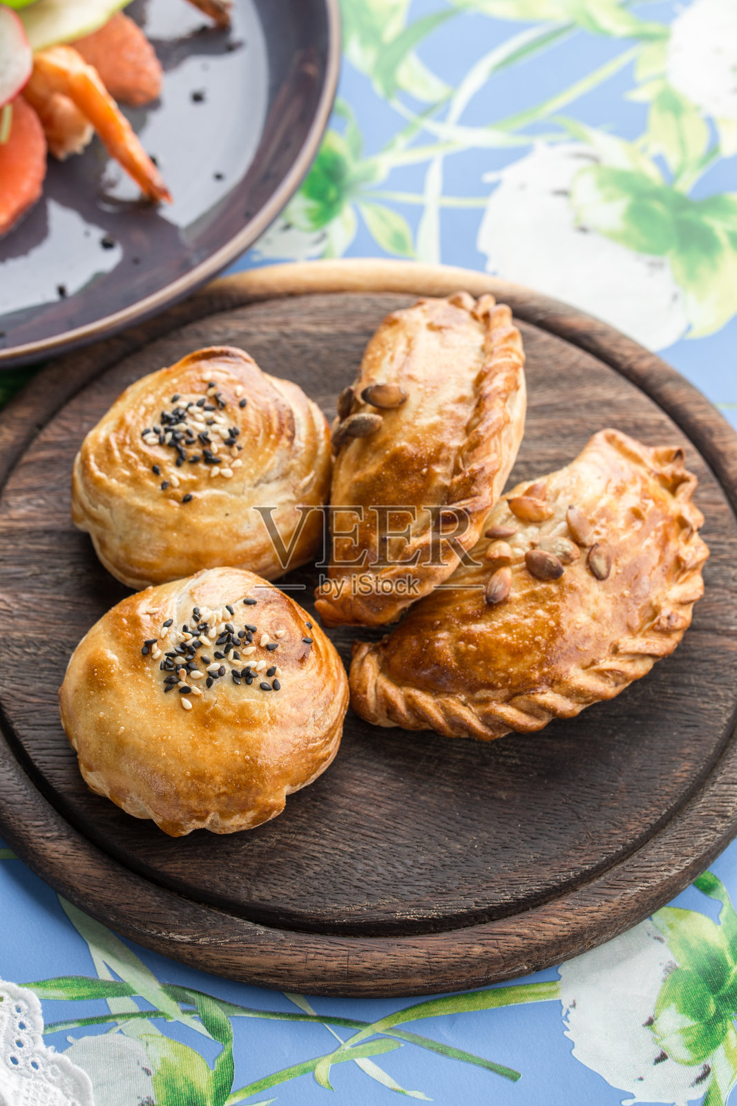 桌上的木盘上放着新鲜出炉的芝麻芝麻家常小圆面包照片摄影图片