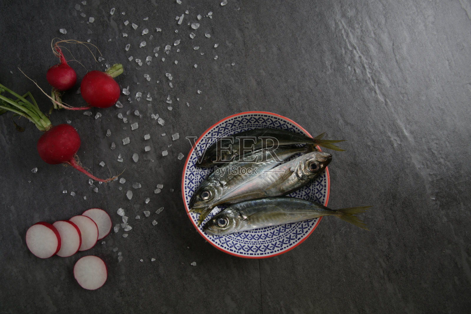 盘子上的鱼在黑色背景照片摄影图片