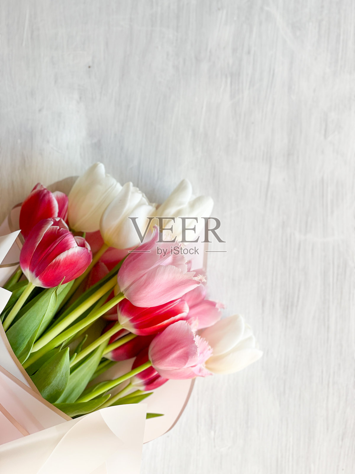 白色的桌子上放着五颜六色的郁金香花束照片摄影图片