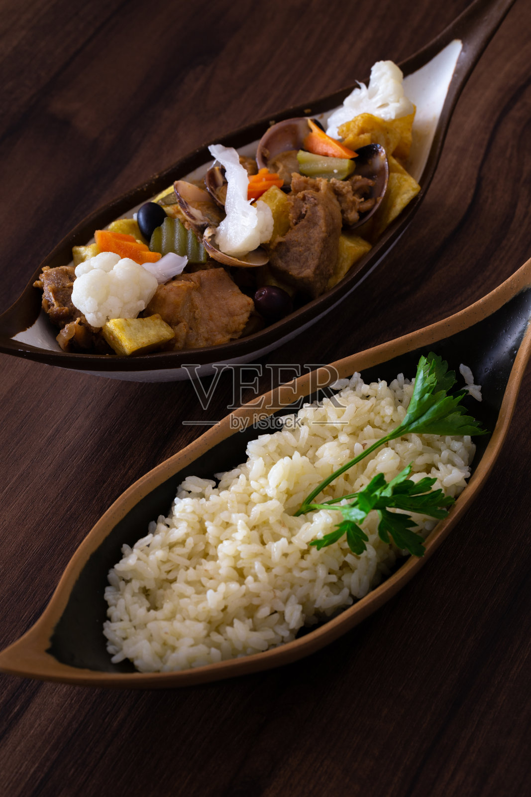 “Carne de Porco a Alentejana”是葡萄牙布拉加Alentejo的一道传统菜肴，里面有蛤蜊、猪肉、炸土豆和泡菜。照片摄影图片