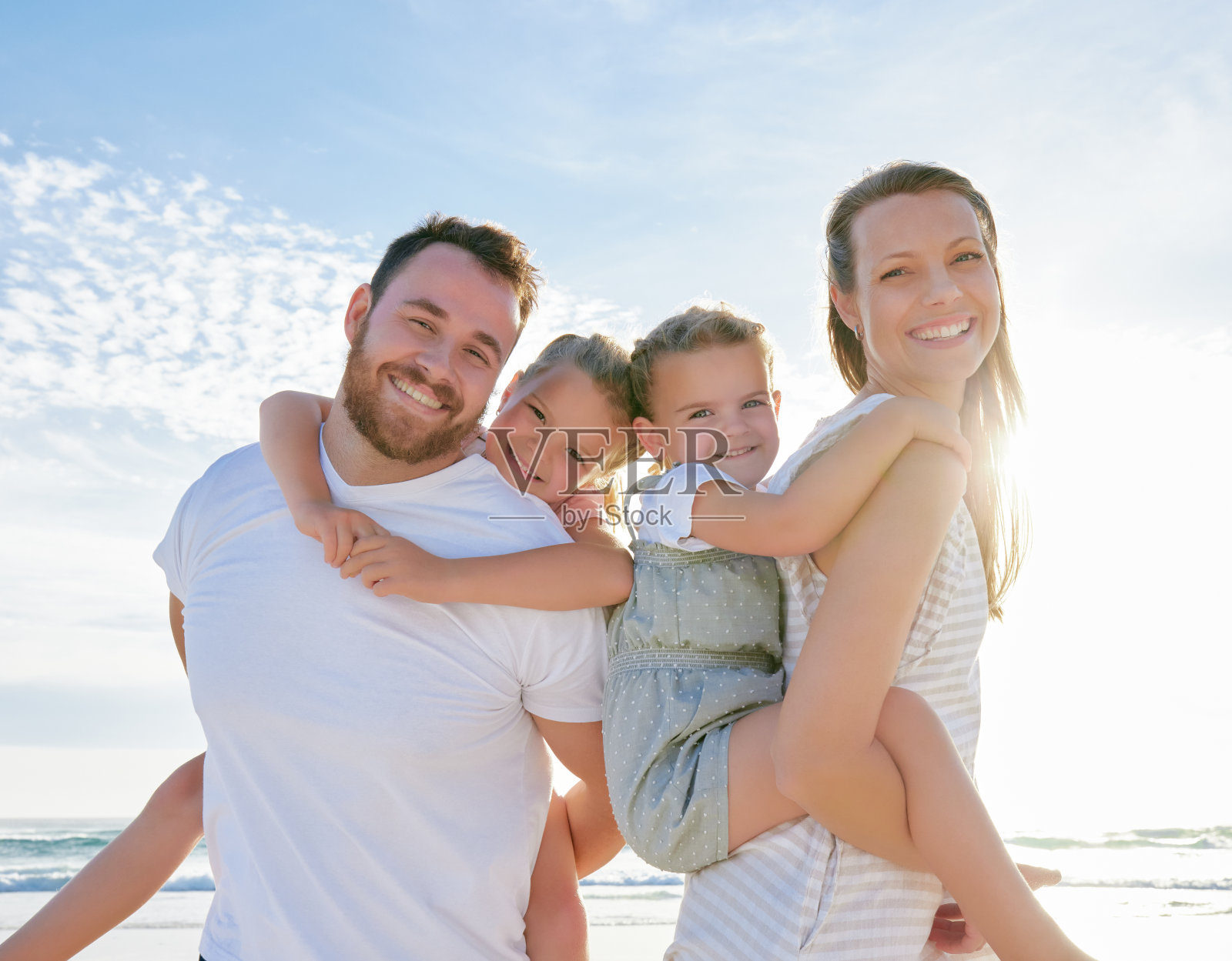 海滩上的幸福家庭：年轻父母和孩子们的度假时光照片摄影图片