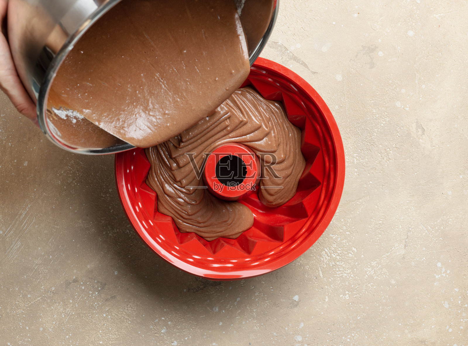 将巧克力蛋糕面团倒入硅胶烘烤形式照片摄影图片