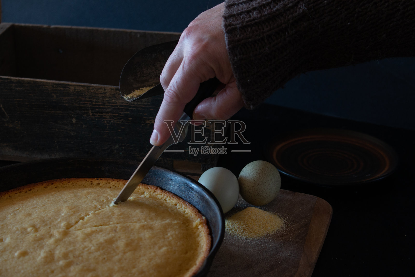 厨房用刀切刚烤好的玉米面包照片摄影图片