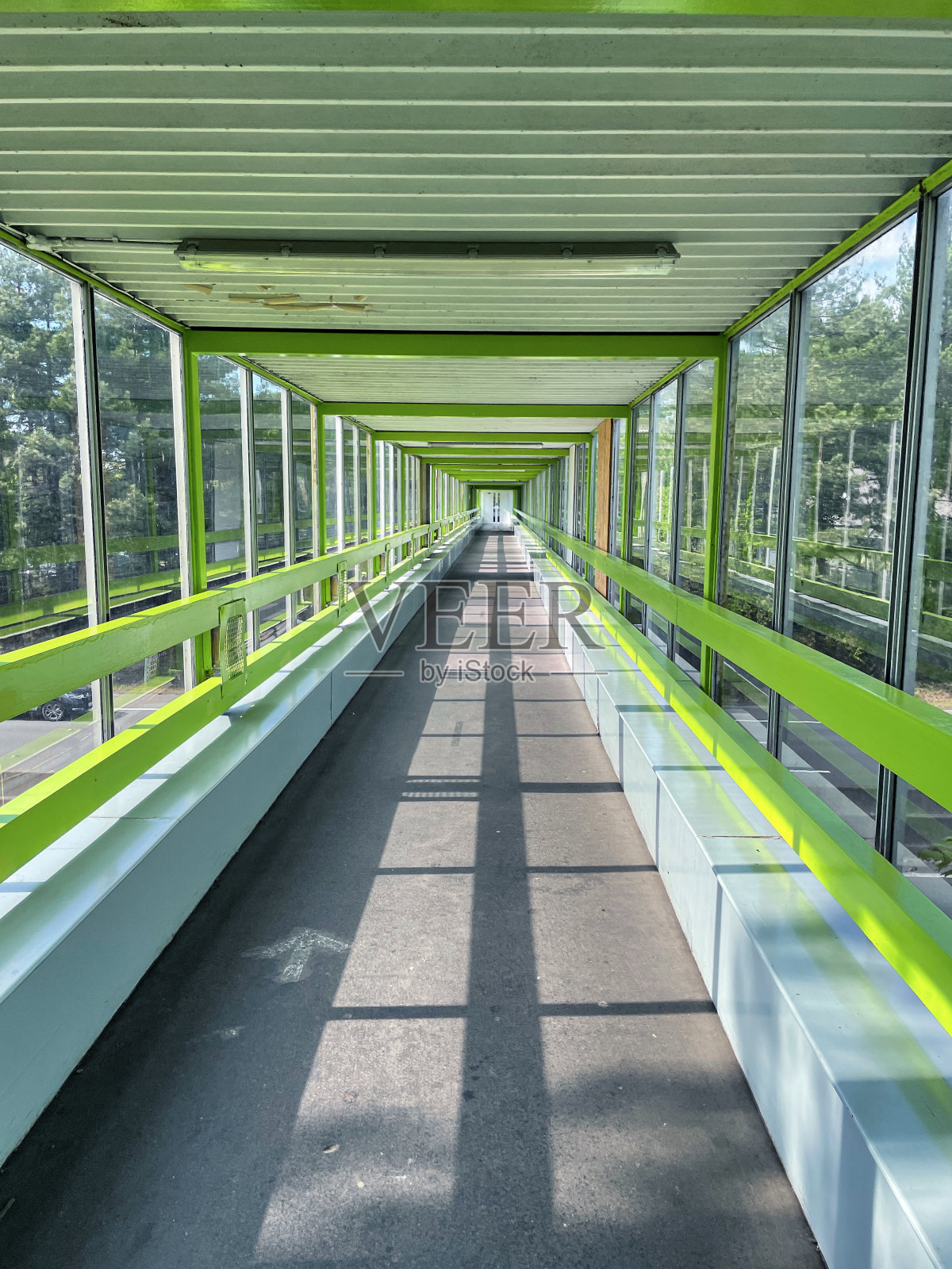 高速公路上的行人天桥的图像，向下看长度空盖桥，玻璃窗户，阳光明媚的日子照片摄影图片