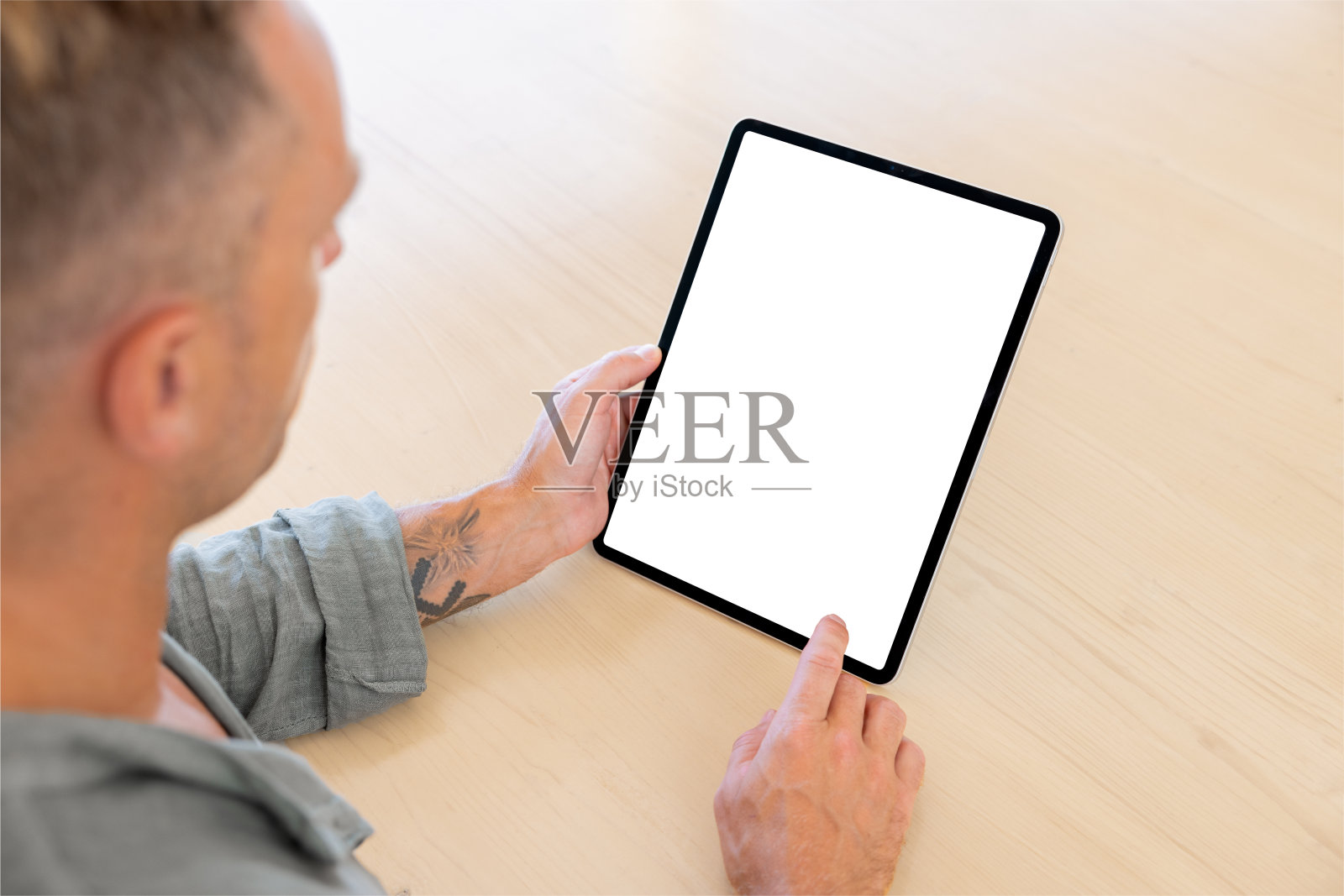 男子使用平板电脑，空白的白色屏幕模型，在肩膀上观看照片摄影图片