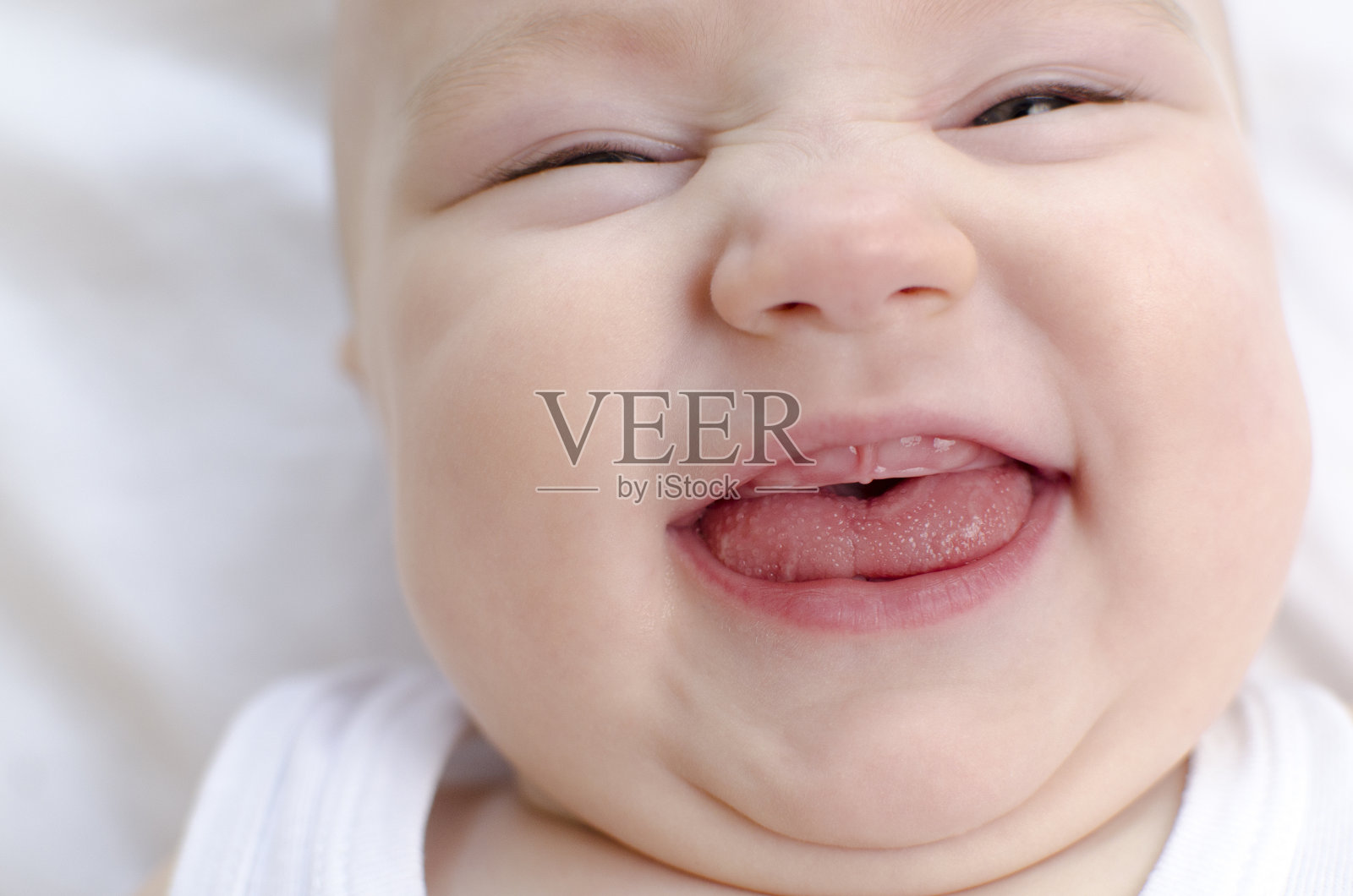 微笑婴儿嘴特写。婴儿主要的生齿。儿童保健和抚慰概念。照片摄影图片