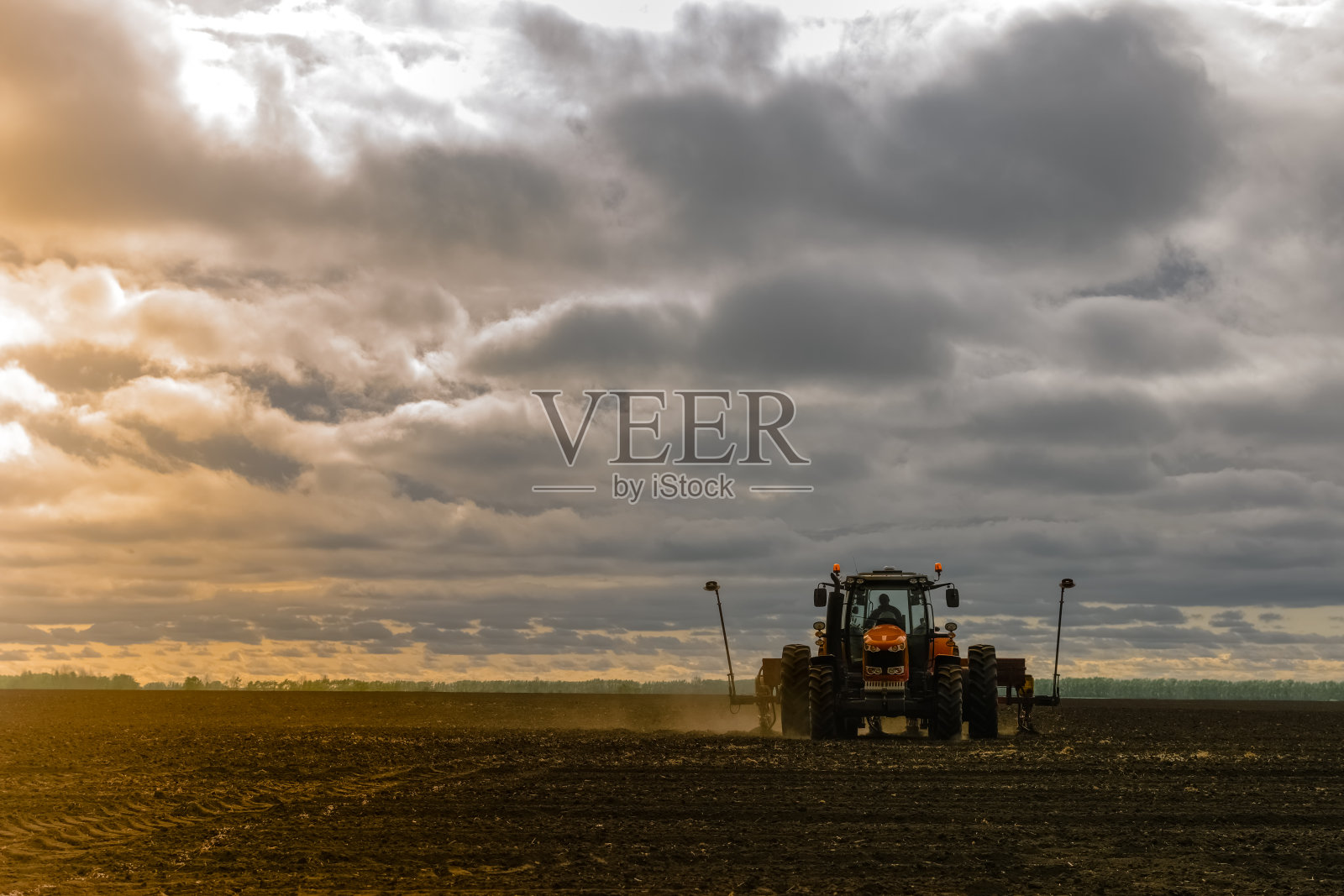 一台带播种机的拖拉机正在种玉米。农业产业发展理念。照片摄影图片