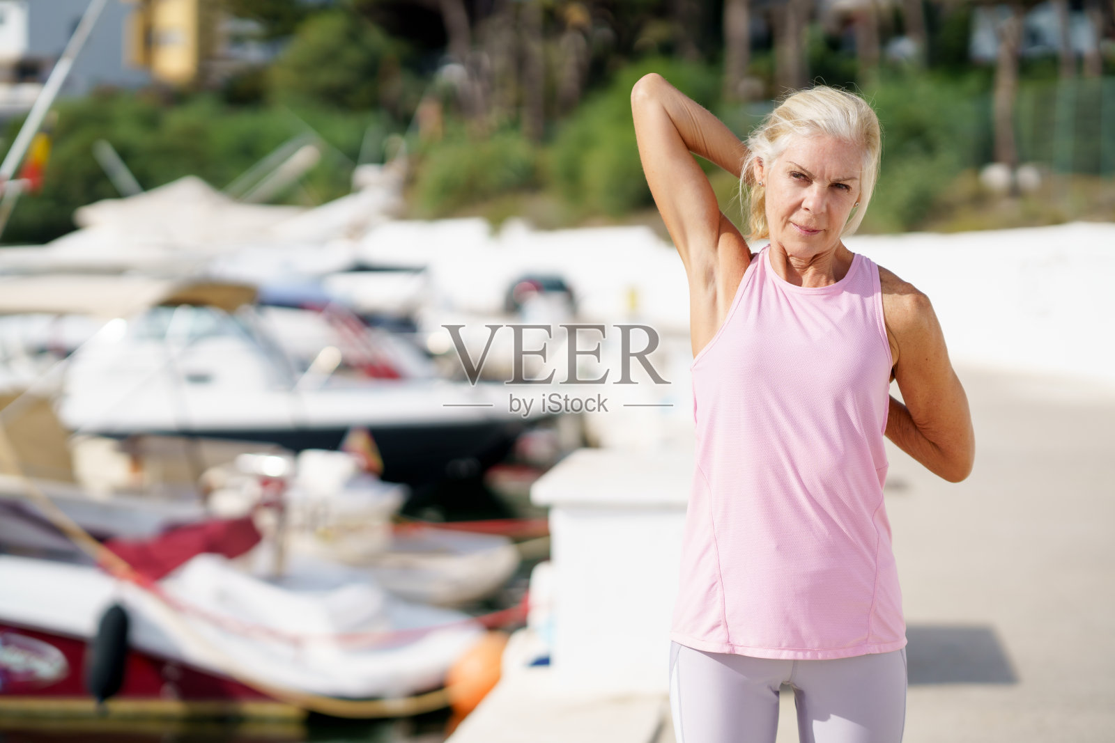 成熟的女运动员运动后伸展肱三头肌。照片摄影图片