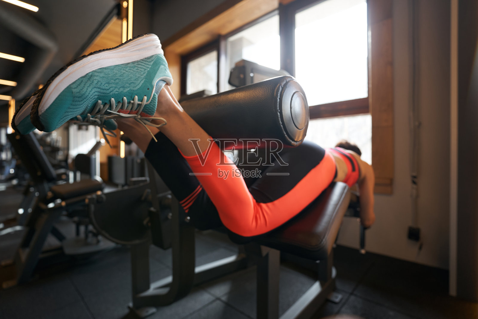 女运动员在健身器材上进行下半身力量练习照片摄影图片