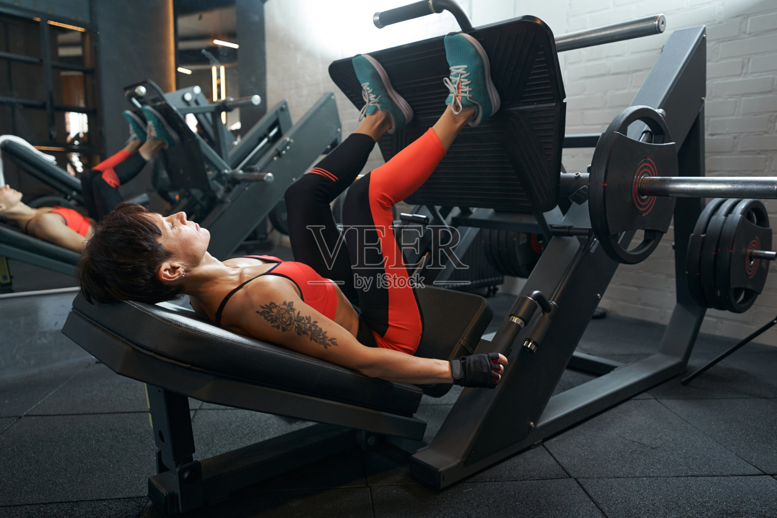 女运动员在健身俱乐部做力量训练照片摄影图片