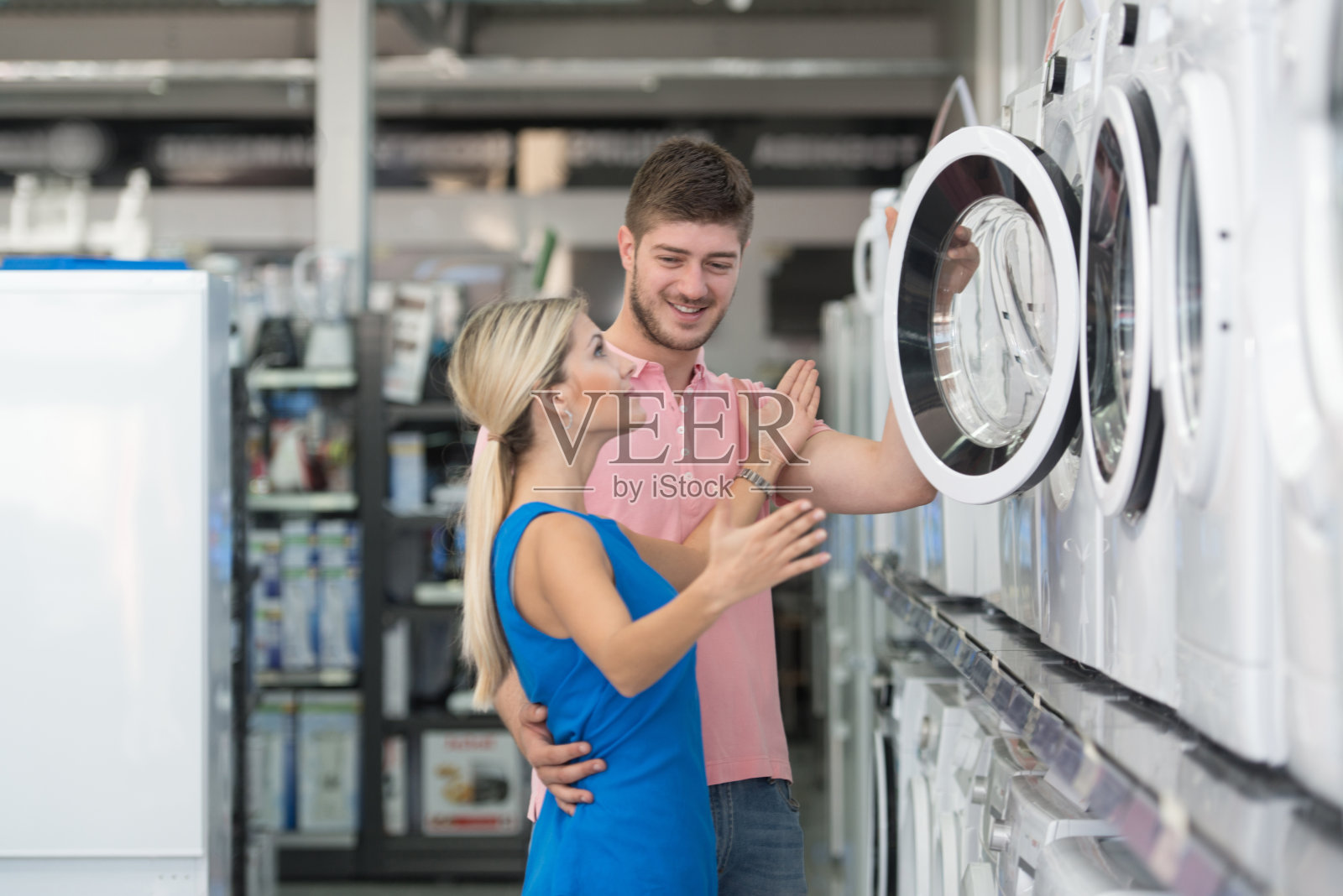 美丽的年轻夫妇在超市购物洗衣机照片摄影图片