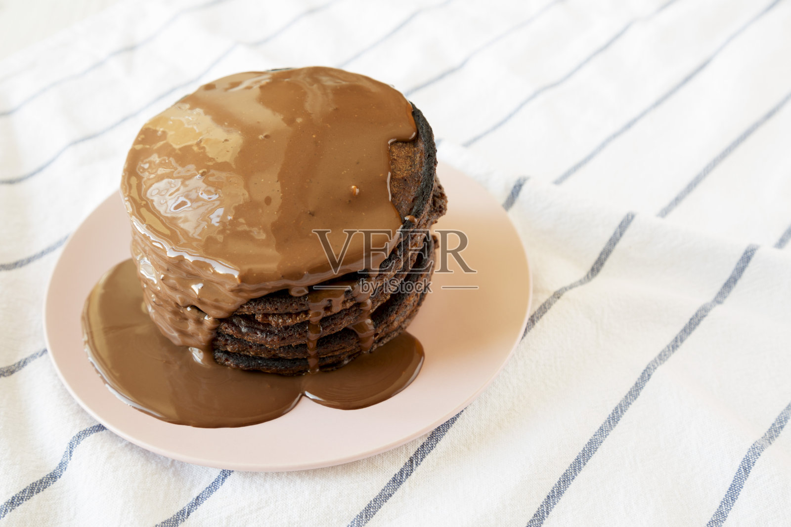 粉色盘子上的自制巧克力煎饼，侧视图。空间的文本。照片摄影图片