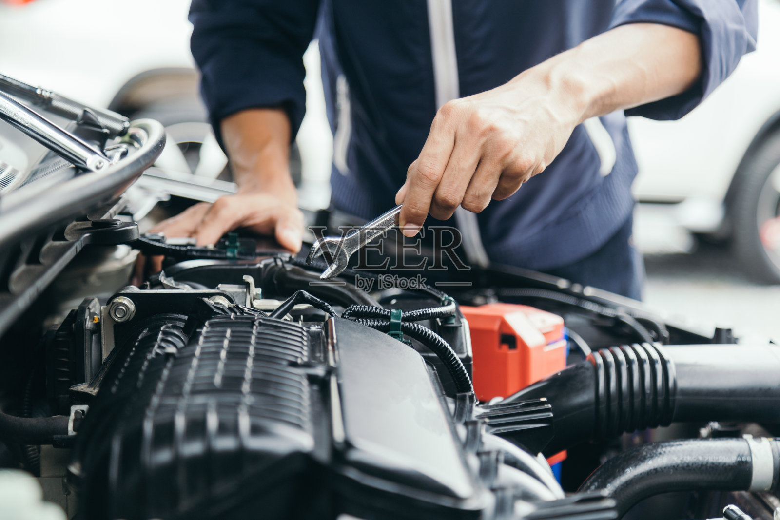 汽车机械修理工手拿扳手修理汽车发动机汽车车间，汽车维修保养，维修服务。照片摄影图片