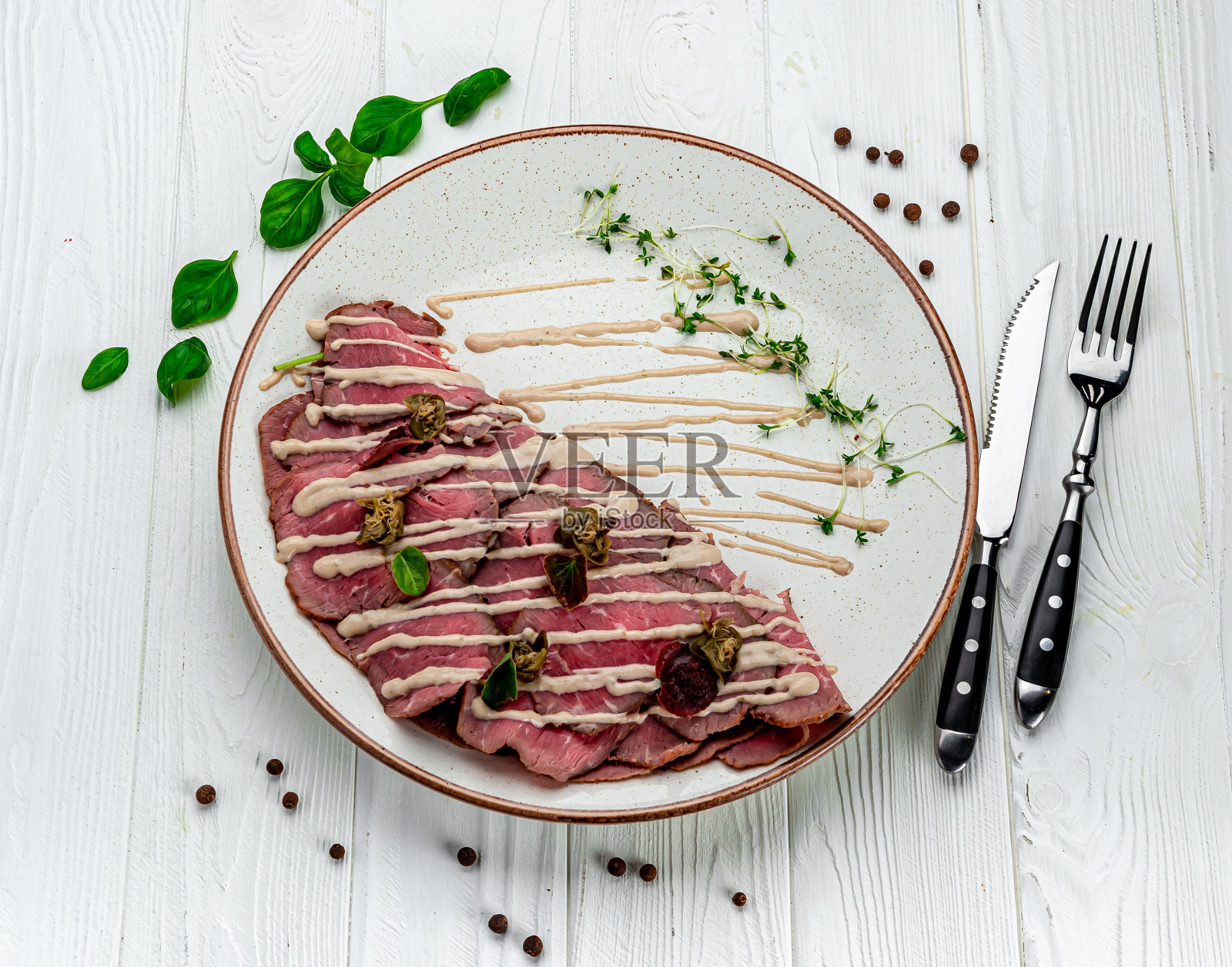 大理石牛肉片配芝麻菜、柠檬和帕尔马干酪。照片摄影图片