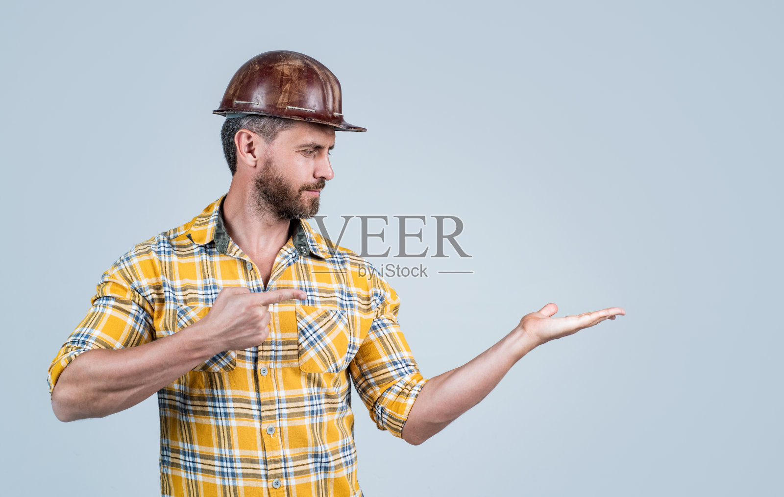 一切都应该是完美的。男人建筑师展示产品。男的穿工人制服。建筑商在头盔。成熟的男人穿格子衬衫。专业的构造师或技工。建筑工程师照片摄影图片