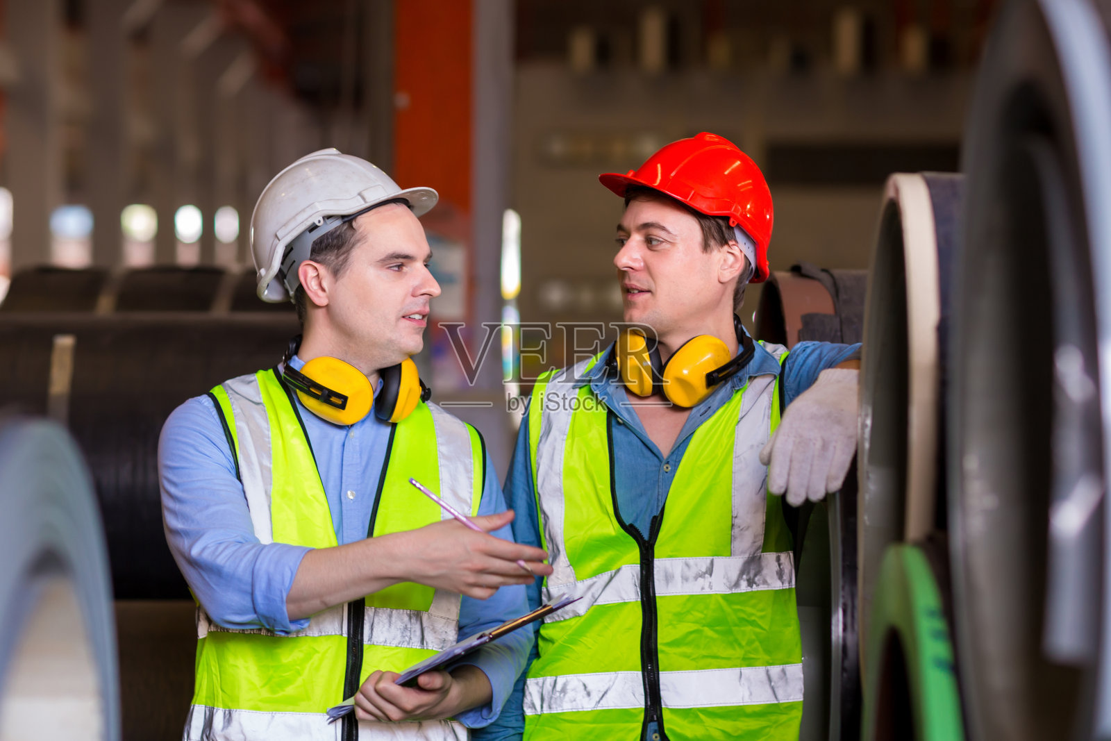 领班或工人在工厂现场检查机器或产品。工程师或技术员检查工厂的材料或机器。工业和工厂。照片摄影图片