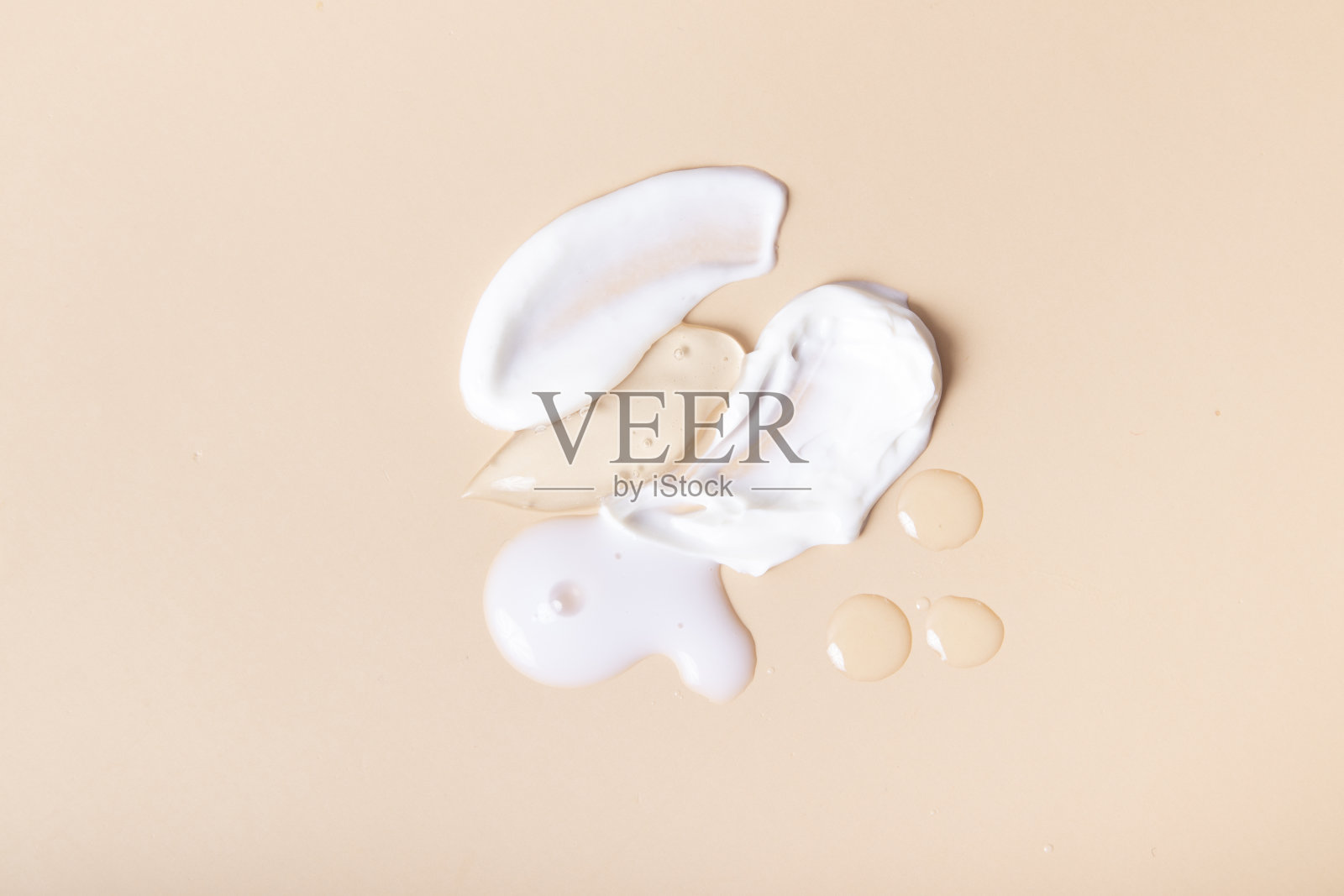 滴和涂抹化妆品顶部视图上的米色背景照片摄影图片