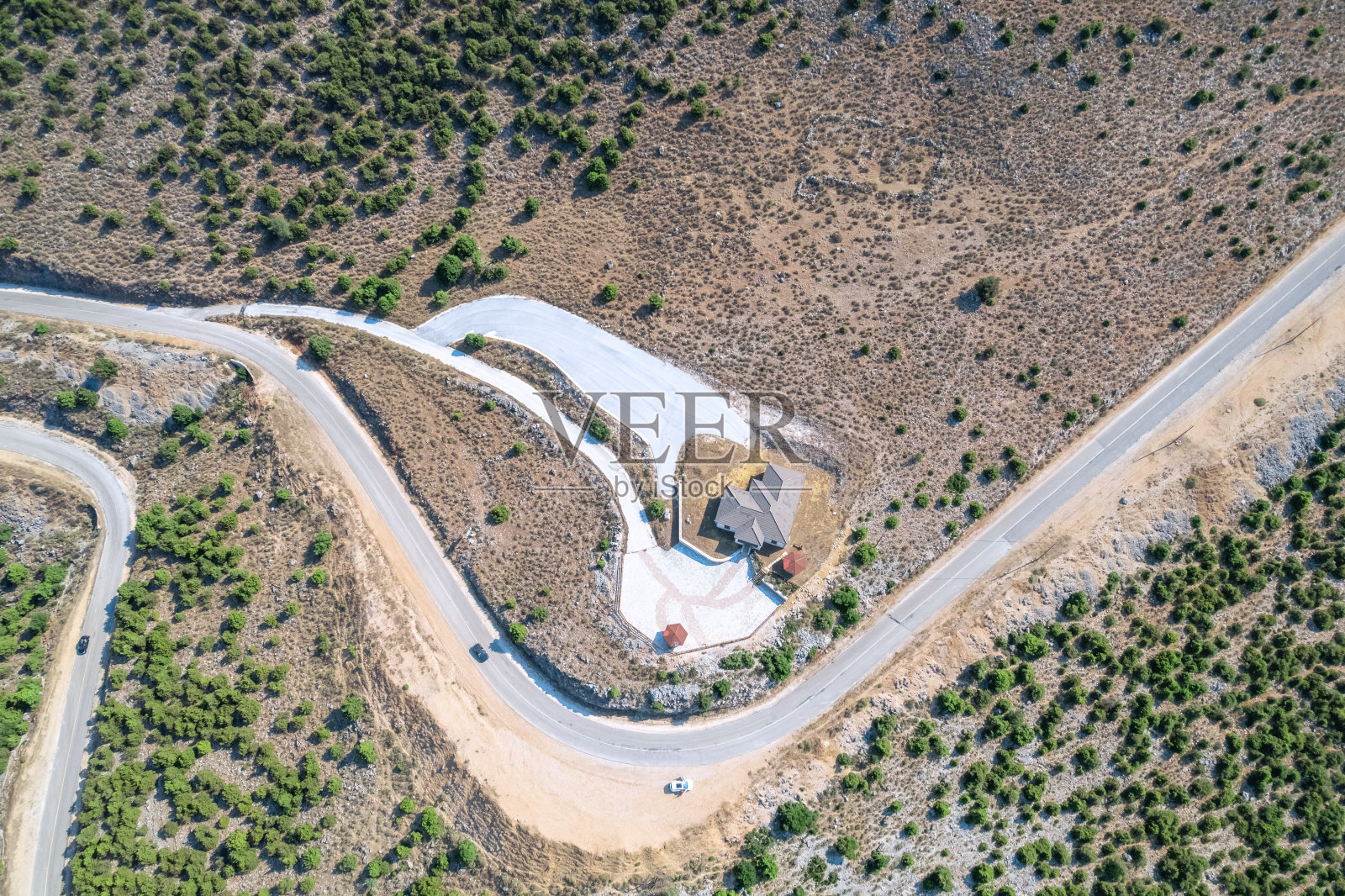 蜿蜒曲折的山路蜿蜒在山间，有小村舍。鸟瞰图。直升飞机,无人机视图照片摄影图片