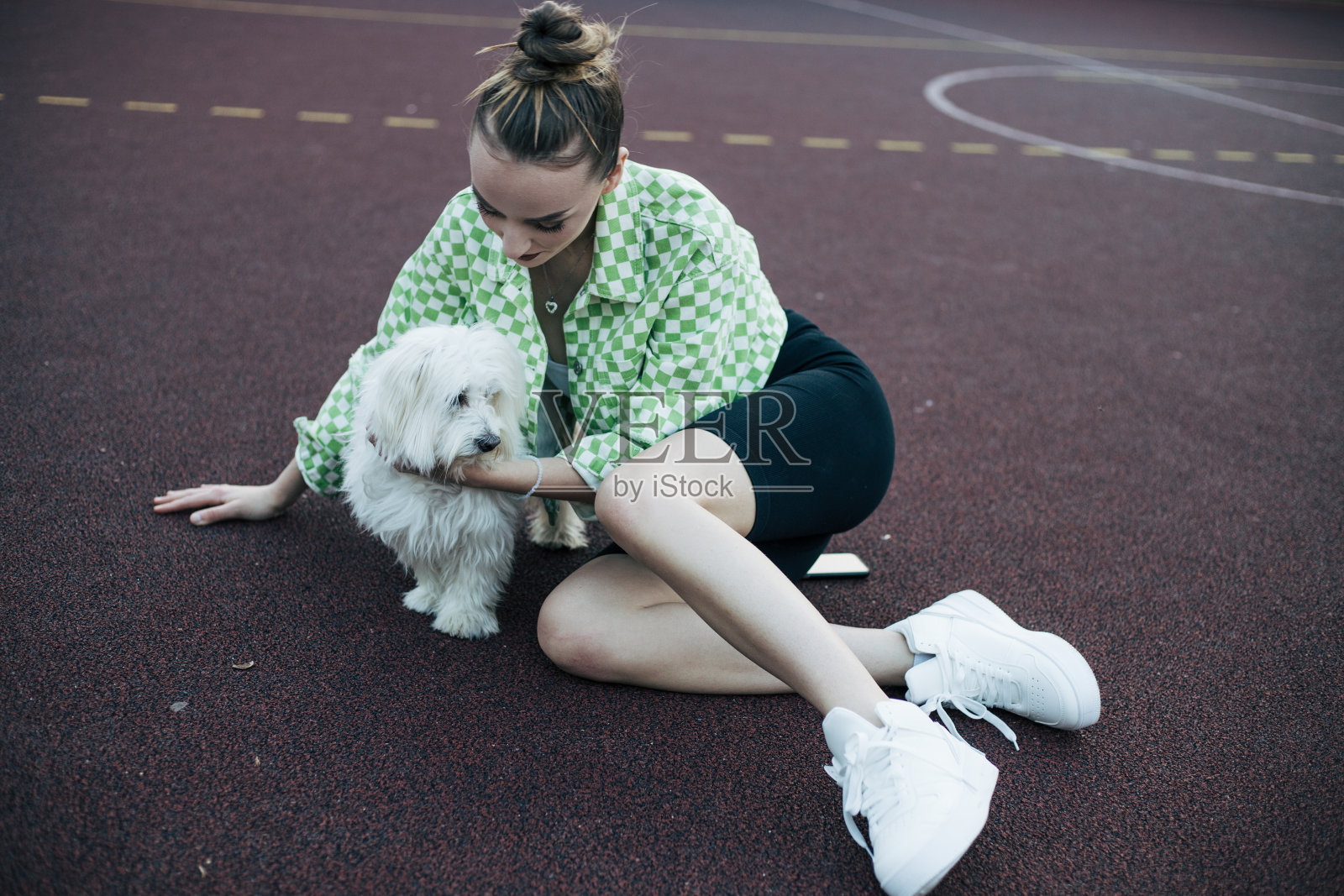 十几岁的女孩和狗在篮球场上玩照片摄影图片