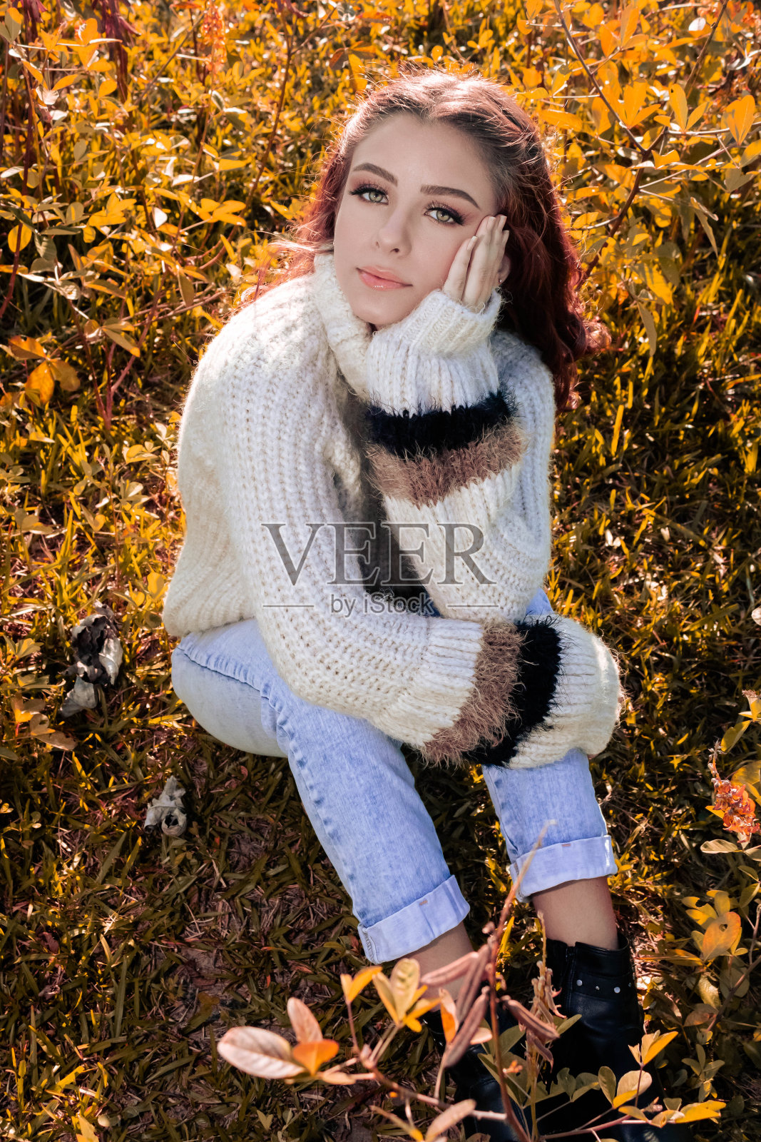 绿眼睛的女孩穿着白色的衬衫在阳光下放松在一个绿色和黄色的田野。提及当地、乡村和文化旅游的旅行和发现。照片摄影图片