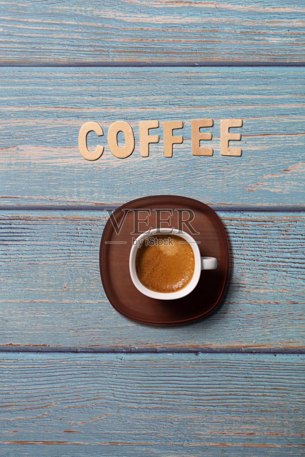 咖啡木字在蓝色的板上与棕色的咖啡服务在白色的帽子与棕色的盘子照片摄影图片