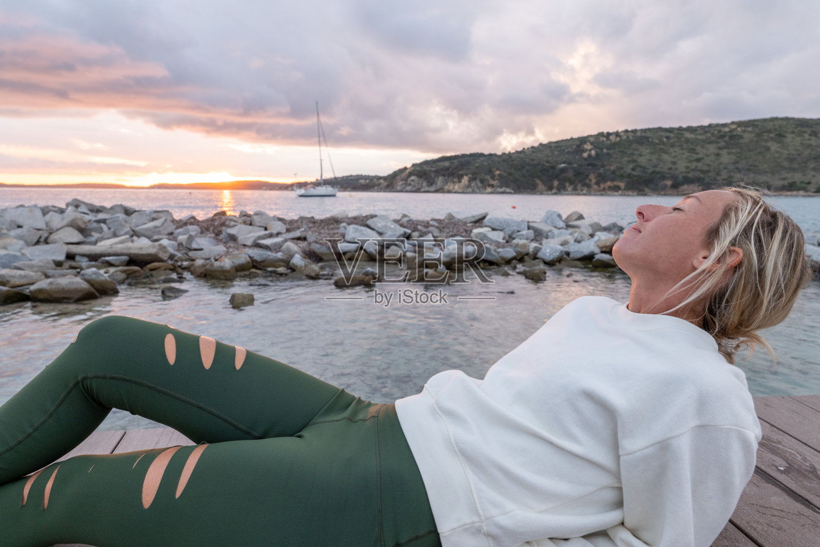 年轻女子在码头上看日落照片摄影图片