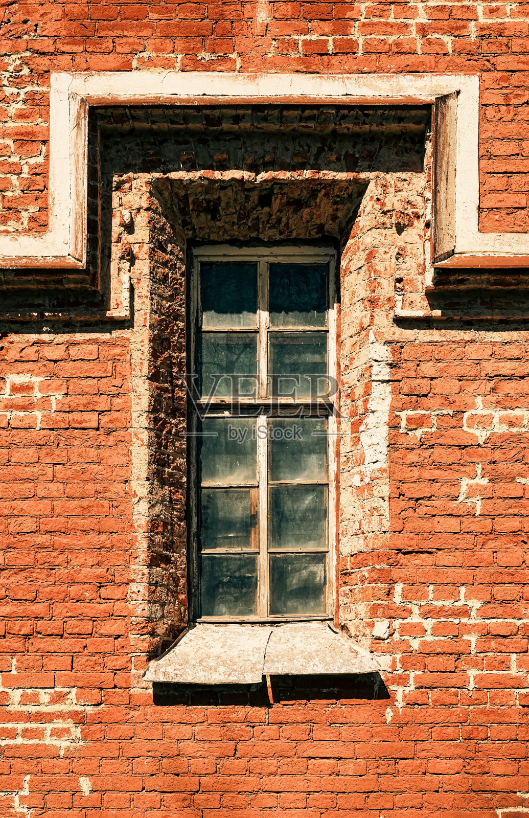 砖墙上有一扇旧窗，旧房子的碎片用天然红砖砌成。垃圾背景或墙纸的想法与复制空间，垂直框架照片摄影图片