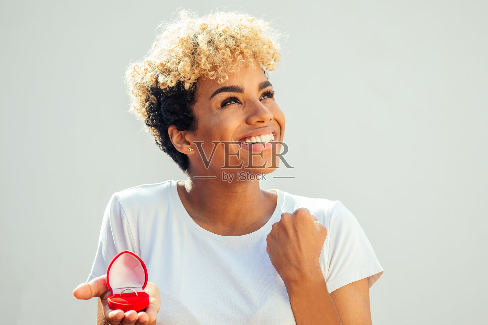 一个非裔美国女人向一个白人工作室背景的男人求婚照片摄影图片