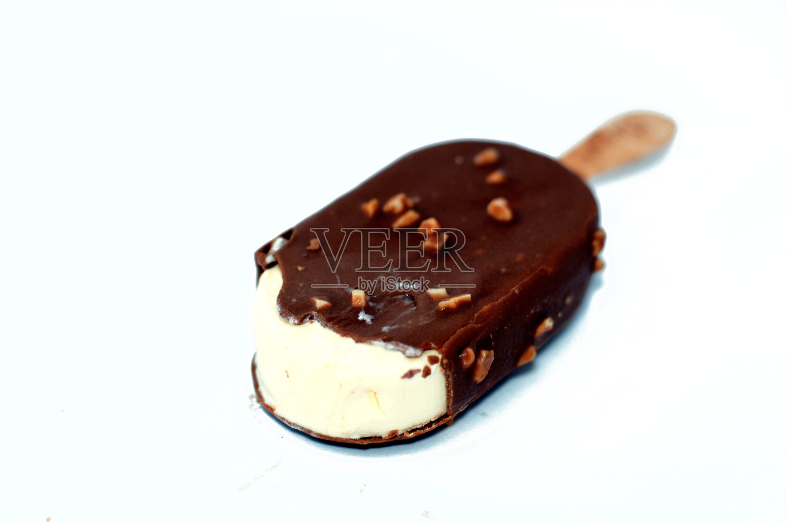 香草口味冰淇淋，搭配棕色碎牛奶巧克力和烤杏仁，香草冰淇淋棒照片摄影图片