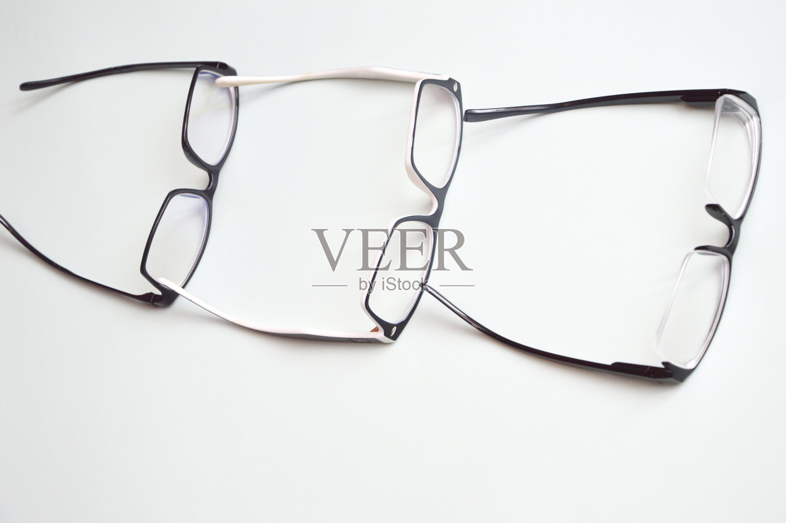光学眼镜，在一个黑色的框架，躺在一排白色的背景。视力矫正，配件，眼科。照片摄影图片