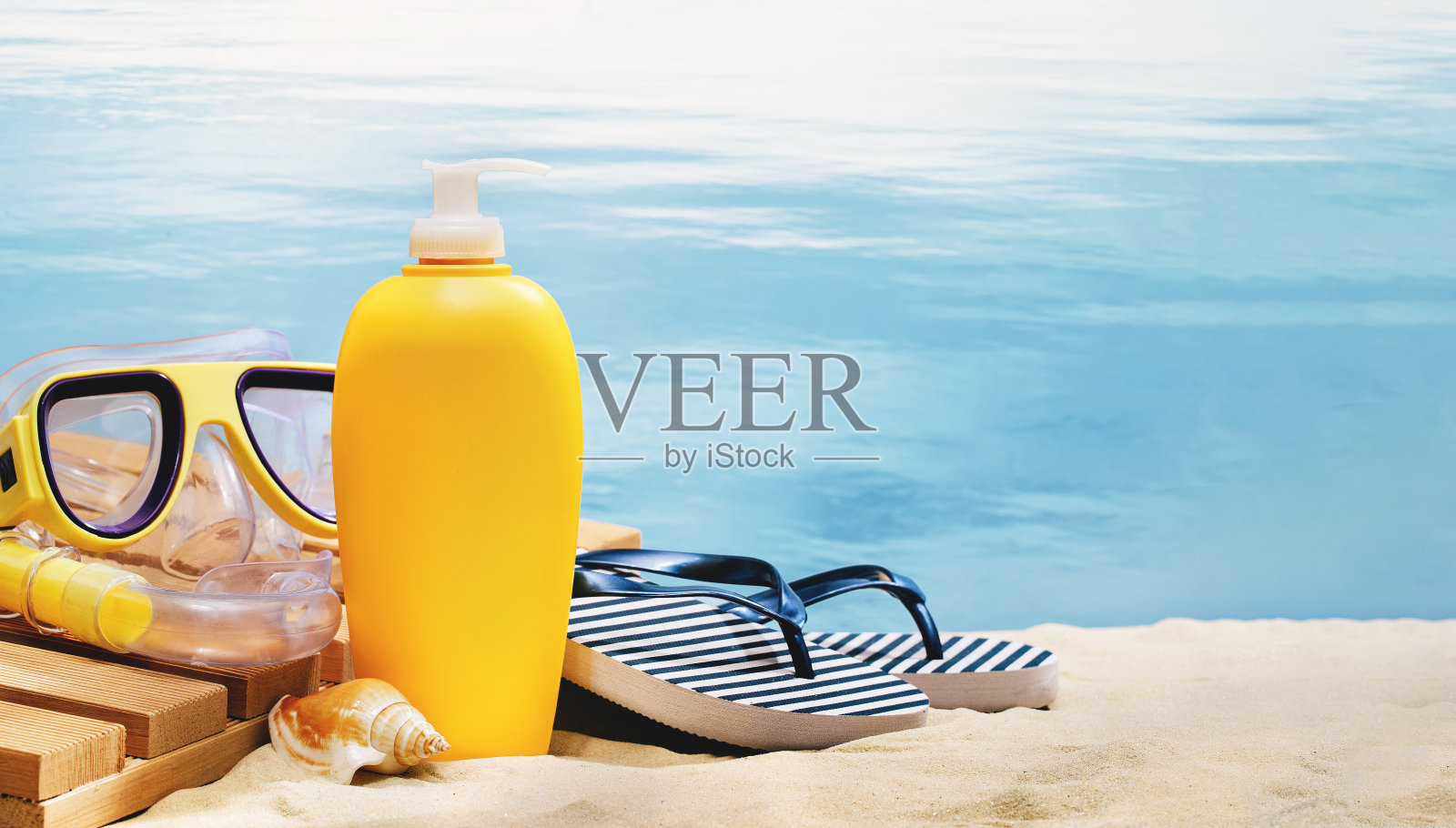 条纹海洋人字拖，在沙滩上涂防晒霜照片摄影图片